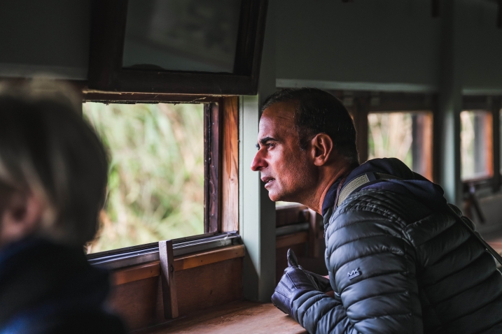 A man looking at of an open hide window at the Janet Kear Hide, WWT Martin Mere Wetland Centre.